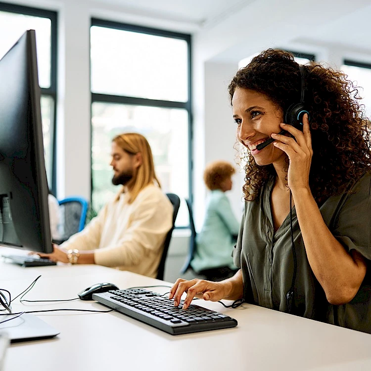 Personen sitzen im Büro am Schreibtisch