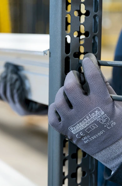 Arbeiter mit Handschuhen befestigt Aluminium Bauteil